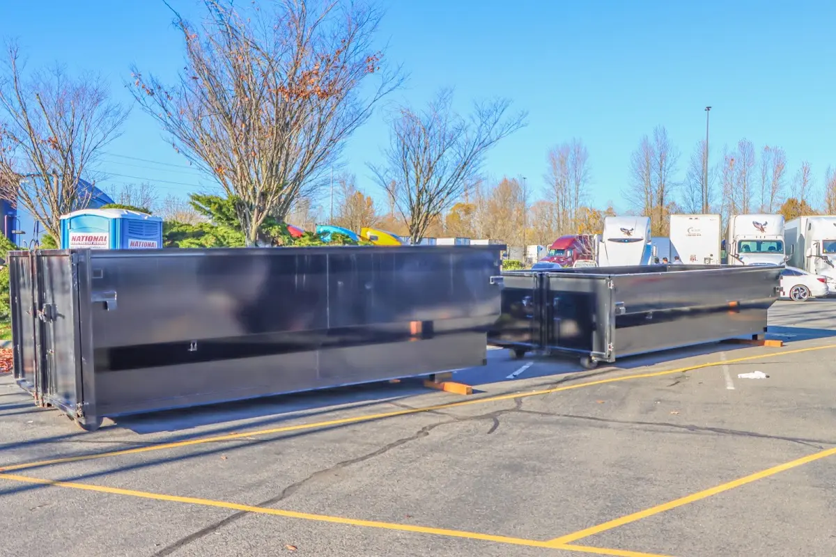 Professional dumpster rental service with roll-off container on residential driveway in College Station